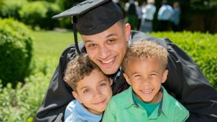 student at graduation with family